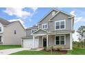 Two-story home with gray siding, white trim, a covered front porch, and an attached two-car garage at 309 Umstead St, Sanford, NC 27330