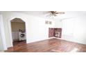 Bright living room with hardwood floors, white trim, a decorative fireplace, and a laundry room alcove at 3117 Cheek Rd, Durham, NC 27704