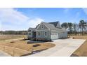 View of craftsman home featuring a large driveway leading to a two-car garage and an expansive lawn at 35 Wheatfield Ln, Youngsville, NC 27596
