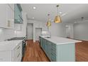 Kitchen featuring white cabinets, light blue island with quartz counters, brass hardware, and stainless steel appliances at 35 Wheatfield Ln, Youngsville, NC 27596