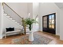 Spacious foyer with hardwood flooring, a staircase with iron railing, and a decorative center table with floral arrangement at 7212 Summer Tanager Trl, Raleigh, NC 27614