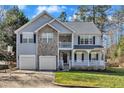 Charming two-story home with stone accents, a two-car garage, and a grassy front yard at 1079 Vauxhall Dr, Apex, NC 27502