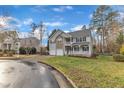 Suburban home featuring two-car garage on a well-maintained street and manicured lawns at 1079 Vauxhall Dr, Apex, NC 27502