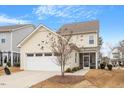 Rear exterior view of home featuring attached garage and screened porch at 109 Beldenshire Way, Holly Springs, NC 27540