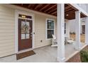Inviting front porch with white pillars and two comfortable chairs at 109 Beldenshire Way, Holly Springs, NC 27540