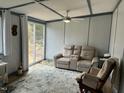 Cozy living room featuring neutral decor, ceiling fan, sliding door with outdoor views, and comfortable seating at 117 Lone Star Dr, Louisburg, NC 27549