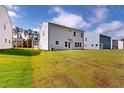 Wide backyard shot with grass, and house with large windows, under a blue sky at 1229 Dimaggio Dr # 8, Raleigh, NC 27616