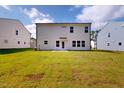 Large grassy backyard with view of back exterior with door and large windows at 1229 Dimaggio Dr # 8, Raleigh, NC 27616