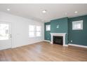 Bright living room featuring a fireplace, large windows, and modern wood flooring with painted accent wall at 1250 Barreto Dr, Wendell, NC 27591