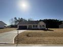 Welcoming single-story home with a spacious driveway, attached garage, and a well-maintained front yard at 145 Magnolia Run Way, Benson, NC 27504