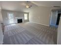 Bright living room with a fireplace, cozy carpet, and a large window offering plenty of sunlight at 145 Magnolia Run Way, Benson, NC 27504