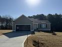 Charming one-story home with an open garage, concrete driveway, and a well-maintained lawn on a sunny day at 175 Magnolia Run Way, Benson, NC 27504