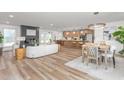 Bright, open living space with a modern fireplace, wood floors, and an open kitchen and dining area at 206 Ellington Rd, Graham, NC 27253