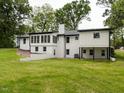 Backyard view of a two story white brick home, with large lawn, and ample lighting at 206 Ellington Rd, Graham, NC 27253
