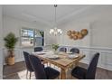Dining room features decorative wainscotting, a rustic table, and a modern chandelier at 25 Bourne Dr, Franklinton, NC 27525
