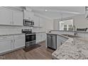 Modern kitchen featuring white cabinets, stainless steel appliances, and granite countertops at 25 Bourne Dr, Franklinton, NC 27525