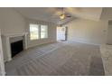 Bright living room features a fireplace, neutral carpet, ceiling fan, and plenty of natural light at 275 Magnolia Run Way, Benson, NC 27504