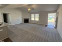 Spacious open-concept living room with fireplace, neutral carpet, and an entry door at 275 Magnolia Run Way, Benson, NC 27504