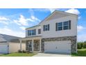 Charming two-story home featuring a brick and vinyl exterior, well-manicured lawn, and two car garage at 276 Hanging Elm Ln, Fuquay Varina, NC 27526