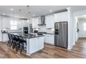 Bright kitchen featuring a large island with seating, stainless steel appliances, and white cabinetry at 294 Arcadius Dr, Clayton, NC 27520
