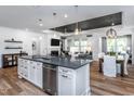 Stylish kitchen with white cabinets, stainless steel appliances, a dark island and hardwood floors at 294 Arcadius Dr, Clayton, NC 27520