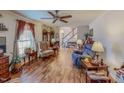 Cozy living room with hardwood floors, ceiling fan, and traditional decor creating a warm ambiance at 3134 Magnolia Ln, Stem, NC 27581