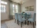 Elegant dining area with a glass table, patterned chairs, modern chandelier, and lots of natural light at 314 Church St # 37, Wendell, NC 27591