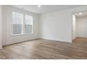 Bright, neutral living room featuring wood-look floors and a dual-window letting in natural light at 318 Church St # 39, Wendell, NC 27591