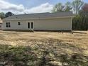 The back of the one-story home features gray siding, a patio area and a large backyard, offering ample space at 327 S Main St, Four Oaks, NC 27524