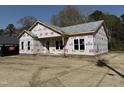 Front exterior of a home under construction with gray shingled roof and brick foundation in a serene setting at 327 S Main St, Four Oaks, NC 27524