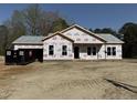 Front exterior of a home under construction, featuring a gray shingled roof and windows, offering a glimpse of its potential at 327 S Main St, Four Oaks, NC 27524