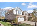 Side view of a brick home with a two-car garage and well-maintained lawn and landscaping at 330 Macallan Dr, Burlington, NC 27215