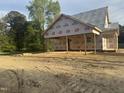 New construction of a home showcasing its framing, brick foundation, and Grip Rite weather barrier at 333 S Main St, Four Oaks, NC 27524