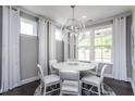 Bright dining room with a modern chandelier, white table and chairs, and lots of natural light at 344 Arcadius Dr, Clayton, NC 27520