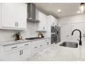 Modern kitchen featuring white cabinets, stainless steel appliances, and a sleek vent hood at 344 Church St, Morrisville, NC 27560
