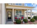 Inviting front porch featuring rocking chairs, decorative plants and a decorative welcome sign at 372 Lynshire Ave, Clayton, NC 27527