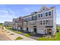 Street view of lovely townhomes with driveways, garages, and attractive landscaping on a sunny day at 509 Sherron Rd # 25, Durham, NC 27703