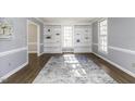Bright living room with a decorative rug, wood floors, built-in bookshelves, and large windows at 849 Jeffreys Rd, Rocky Mount, NC 27804