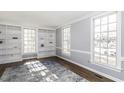 Bright living room with a decorative rug, wood floors, built-in bookshelves, and large windows at 849 Jeffreys Rd, Rocky Mount, NC 27804