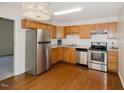View of kitchen with wood cabinets and stainless steel appliances at 113 Belgium Pl, Zebulon, NC 27597
