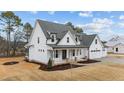 Charming two-story home with a welcoming porch and a convenient three-car garage at 120 Lane Farms Way Way, Holly Springs, NC 27540