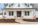 Inviting front porch featuring brick accents, white columns, and a stylish double-door entrance at 120 Lane Farms Way Way, Holly Springs, NC 27540