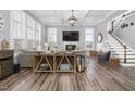 Bright living room featuring high ceilings, modern lighting, a fireplace, and wood-look floors at 132 Mystic Pine Pl, Apex, NC 27539