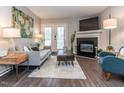 Inviting living room with a fireplace, neutral paint, and laminate wood flooring at 1620 Oakland Hills Way, Raleigh, NC 27604