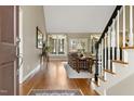 Inviting entryway featuring hardwood floors, staircase, and views into the living room with lots of natural light at 217 Old Pros Way, Cary, NC 27513