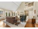 Spacious living room with vaulted ceilings, a stone fireplace, built-in shelving, and large windows at 217 Old Pros Way, Cary, NC 27513