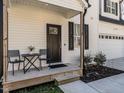 Close up of the front porch with seating, a black front door, and well-kept landscaping at 2218 Christian Light Rd, Fuquay Varina, NC 27526