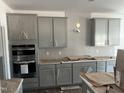 Modern kitchen showcasing gray cabinets, stainless steel appliances, a stylish backsplash, and ample counter space at 249 Tidal Pool Way, Cary, NC 27519