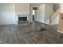 Bright living room featuring wood floors, a cozy fireplace, staircase to the second floor, and natural light at 249 Tidal Pool Way, Cary, NC 27519