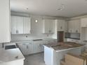 Spacious kitchen with white cabinets, a tile backsplash, quartz counters, and stainless steel appliances at 253 Tidal Pool Way, Cary, NC 27519